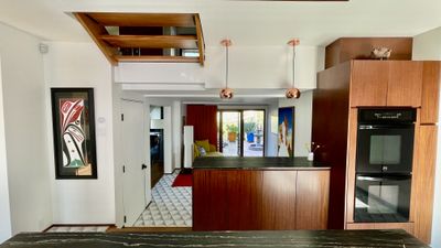 Open-plan kitchen remodel with copper pendant lights and marble countertop