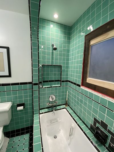 Vintage green tile detail around arched tub alcove